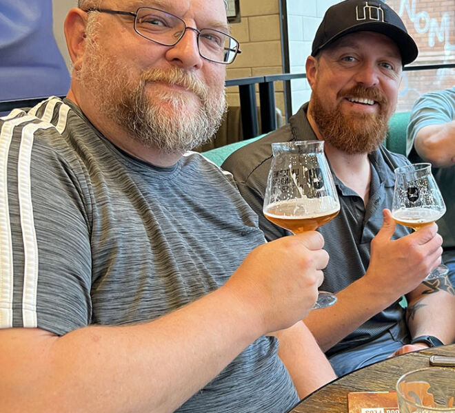 two brothers enjoying beer while smiling