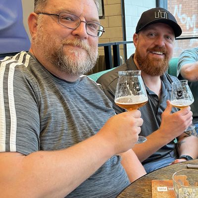 two brothers enjoying beer while smiling