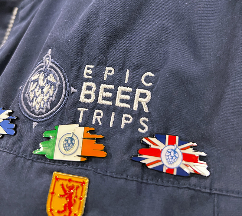 Blue Epic Beer Trips jacket with hop flag pins