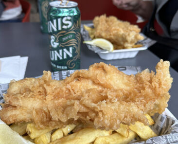 authentic fish and chips with beer can in background