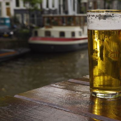 pint of beer on a table with Amsterdam canals in background