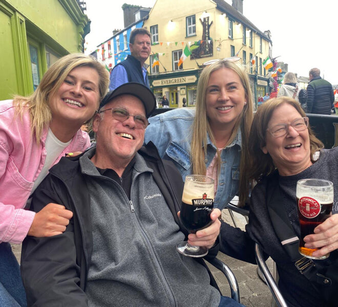 smiling beer trippers outside of a pub in Ireland