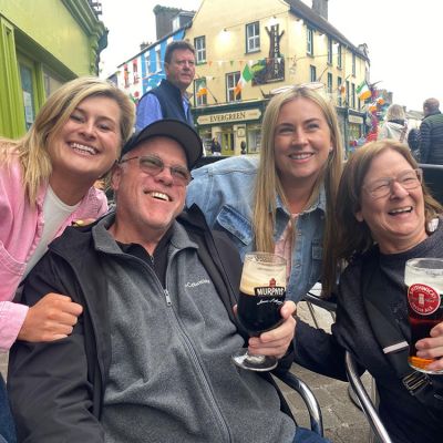 smiling beer trippers outside of a pub in Ireland