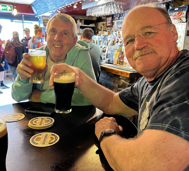 happy beer trippers with pints of beer at local pub in Ireland