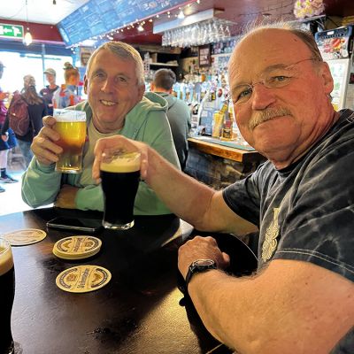 happy beer trippers with pints of beer at local pub in Ireland