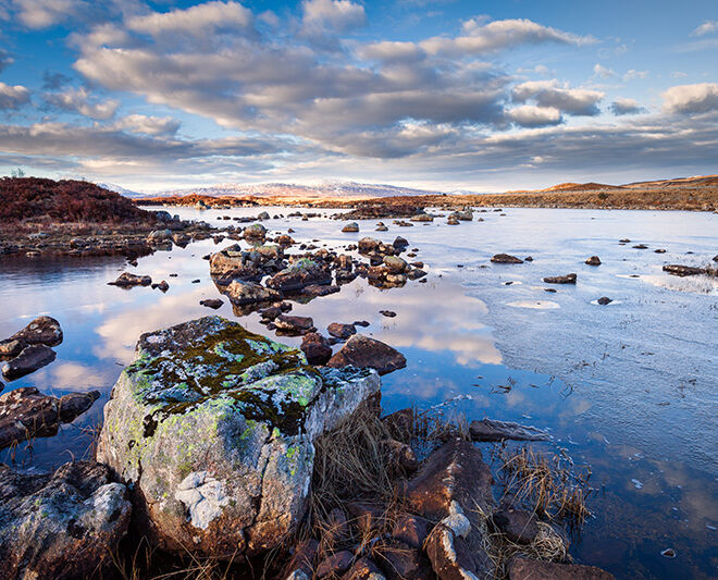 reflection of stone on water in Rannoch Moor Scotland